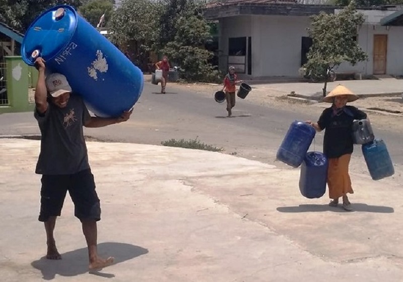 Sejumlah warga sedang membawa tampungan air bersih ke lokasi antrian bantuan air bersih di Desa Karangrejo, Pucakwangi / Istimewa (FB Ali Irham)