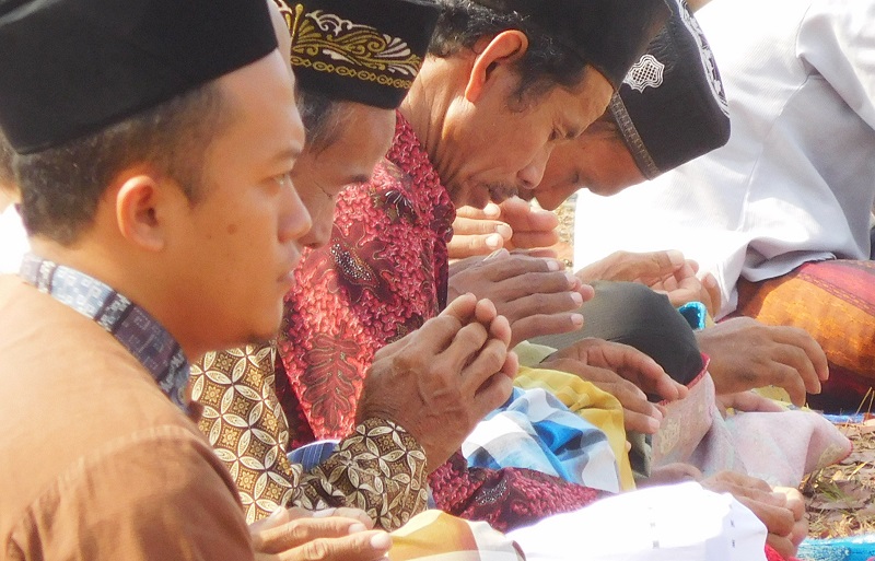 Jamaah khusyuk berdoa saat shalat istisqa di Lapangan Sepak Bola Desa Sokopuluhan, Pucakwangi, Jum'at (1/11/2019) / Clakclik.com