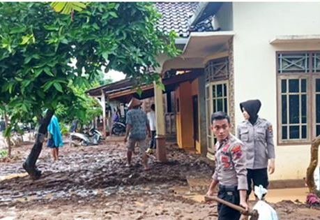 Warga dibantu aparat kepolisian membersihkan lumpur di di rumah mereka pasca banjir / Radar Kudus