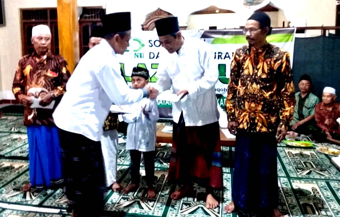 Pengurus LAZISNU Pucakwangi menyerakhan santunan di Desa Tanjungsekar, Jum'at (19/12/2019 / Istimewa